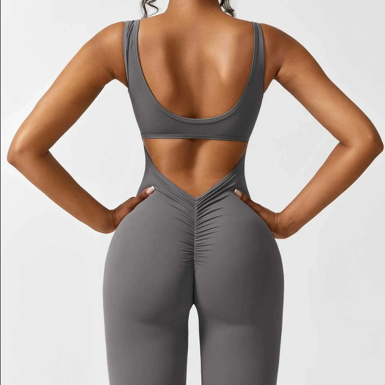 Gray push-up jumpsuit featuring a scooped back and ruching detail, designed for a flattering, form-fitting silhouette.