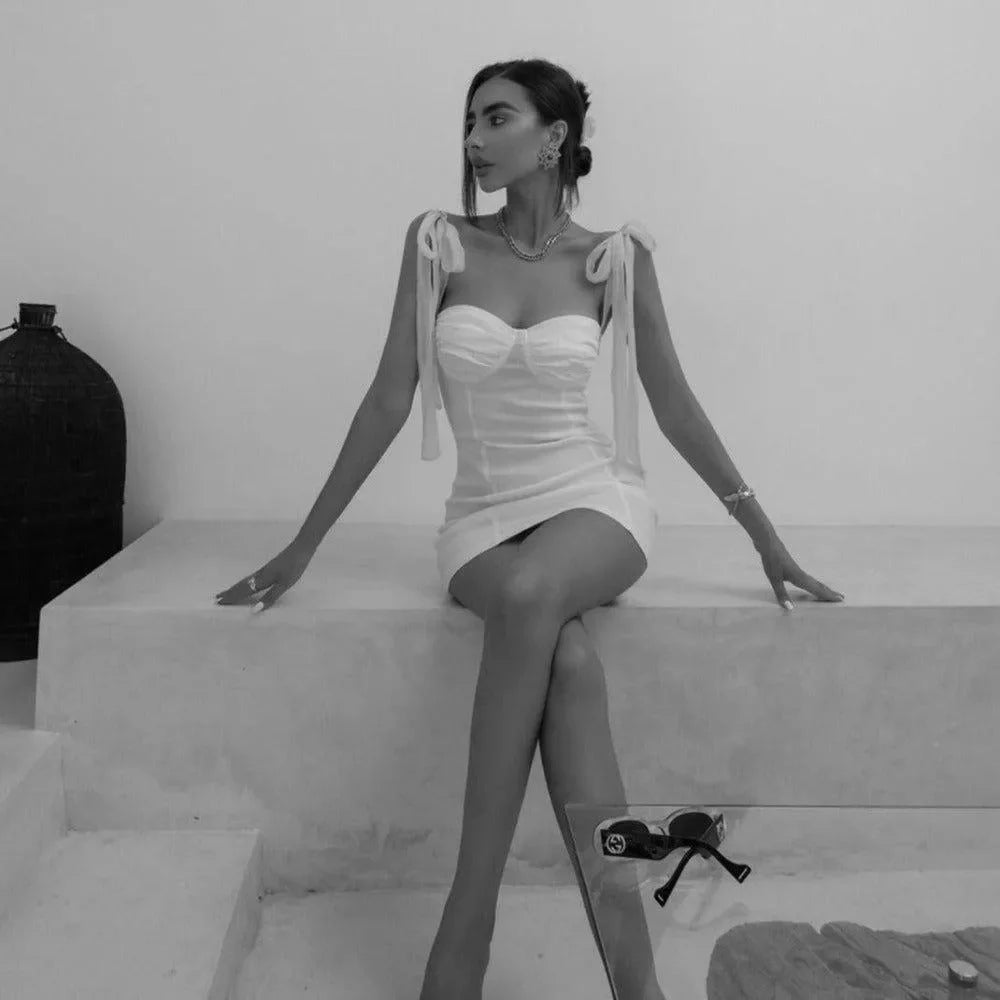White mini dress with tie-shoulder straps for evening look.