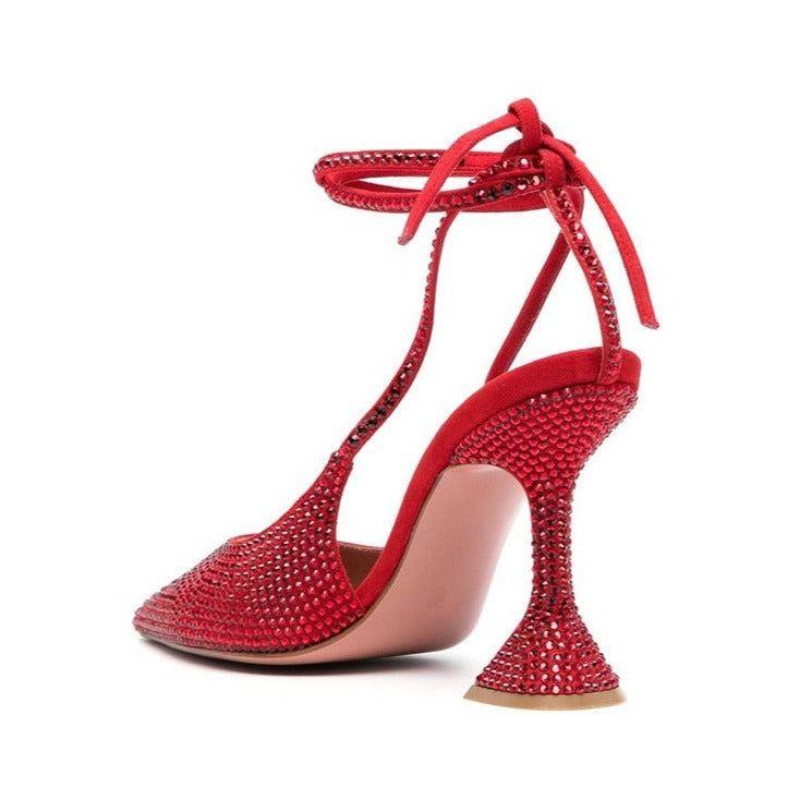 Red high-heeled shoe with rhinestone embellishments on a white background