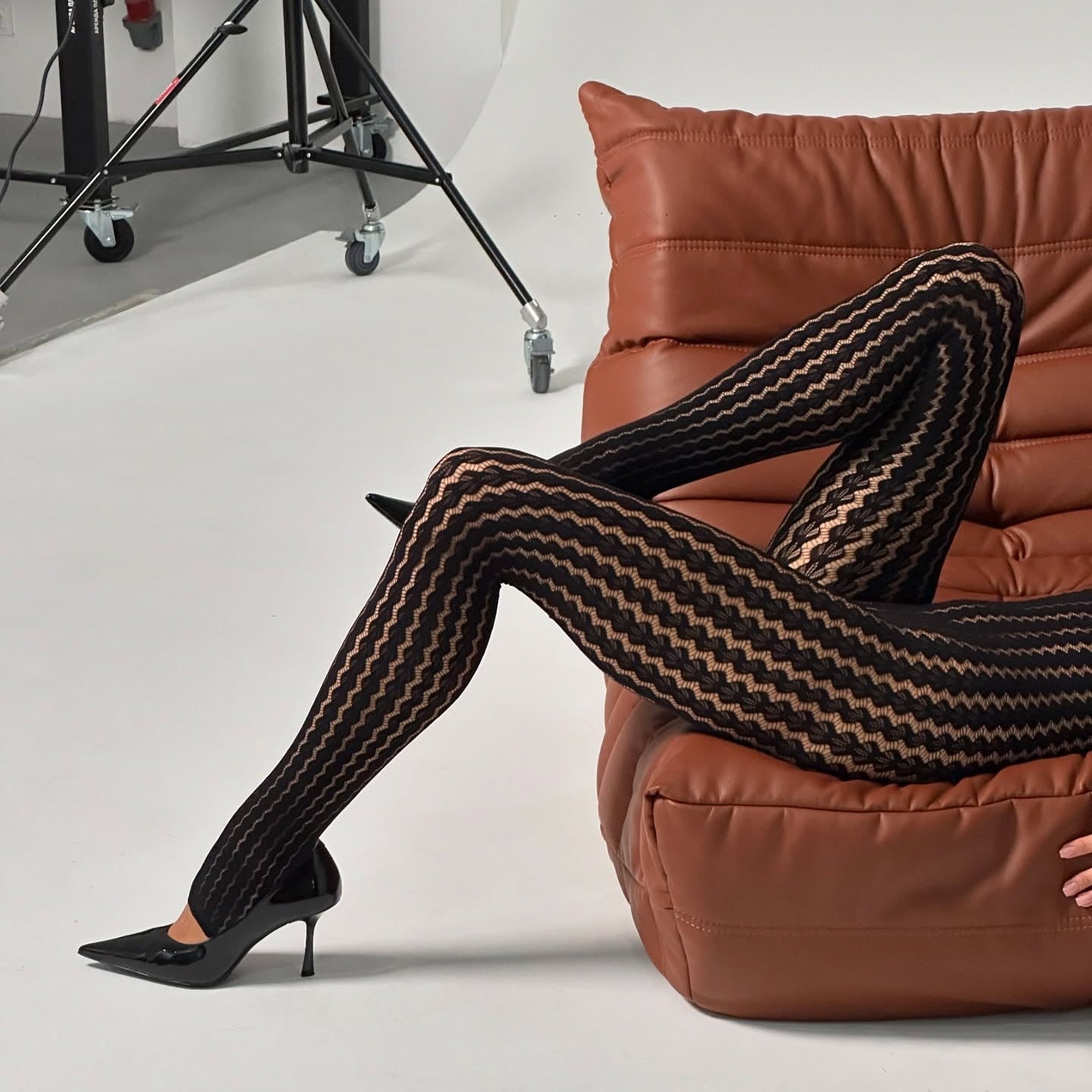 black patterned tights and pointed-toe stiletto heels, chic evening look