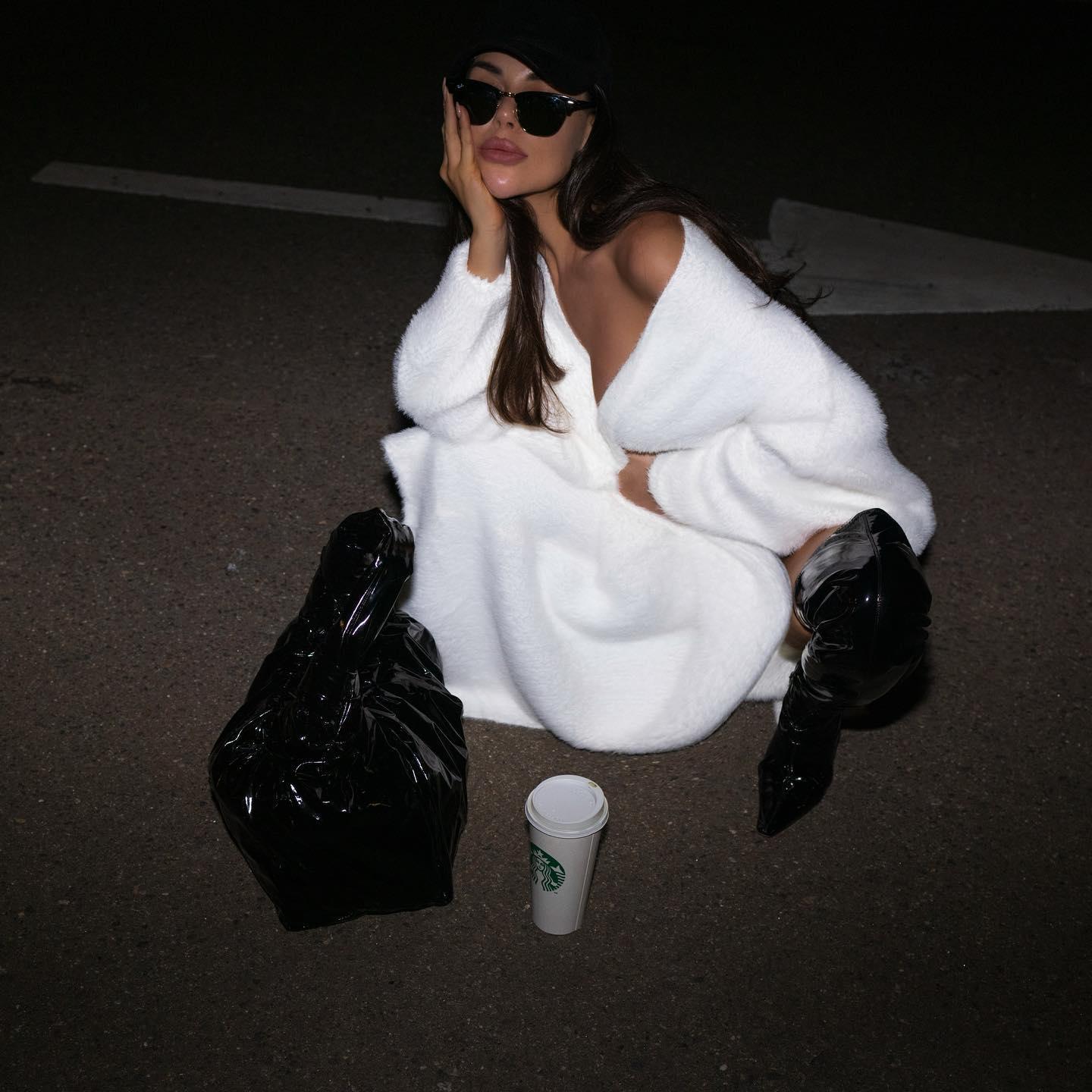 Oversized white long sleeve cardigan layered over a minimalist look, styled with sleek black accessories.
