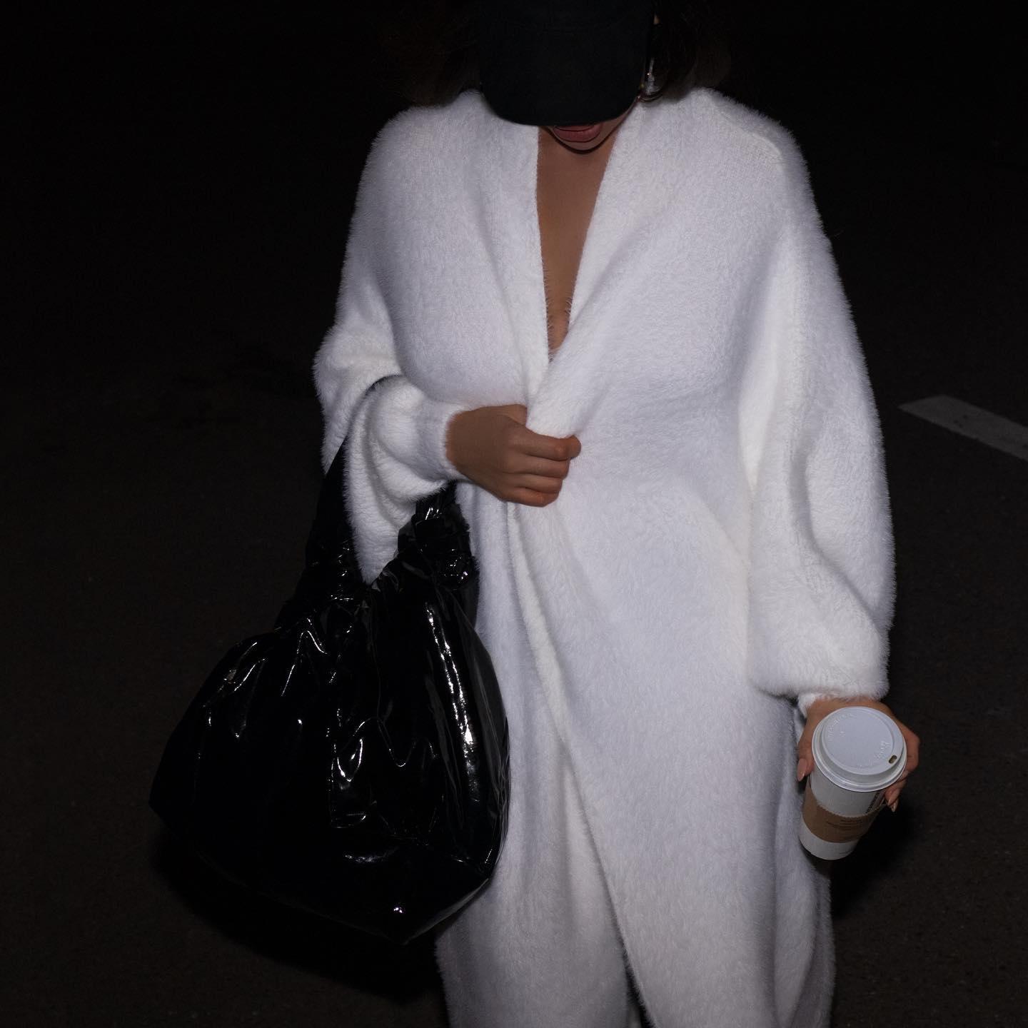 Oversized long sleeve cardigan in misty white, featuring a cozy texture, styled with a black bag and casual attire.