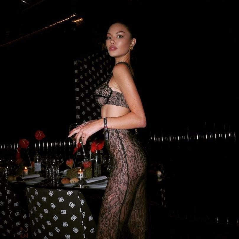 Black lace maxi skirt set featuring a sheer design and matching bralette, styled for an elegant evening look.