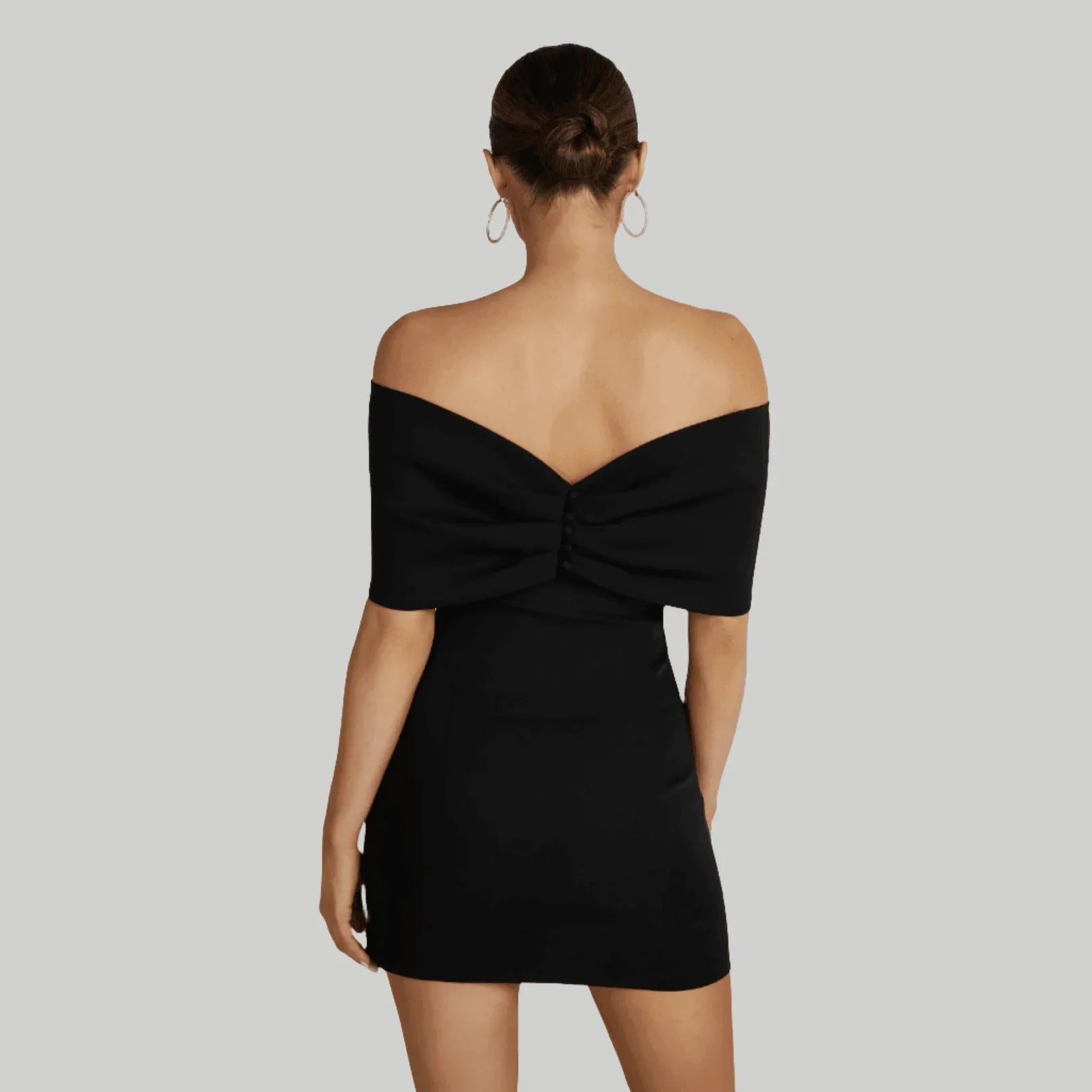 Off-shoulder black mini dress with a bow detail at the back, perfect for a night out or elegant occasion.