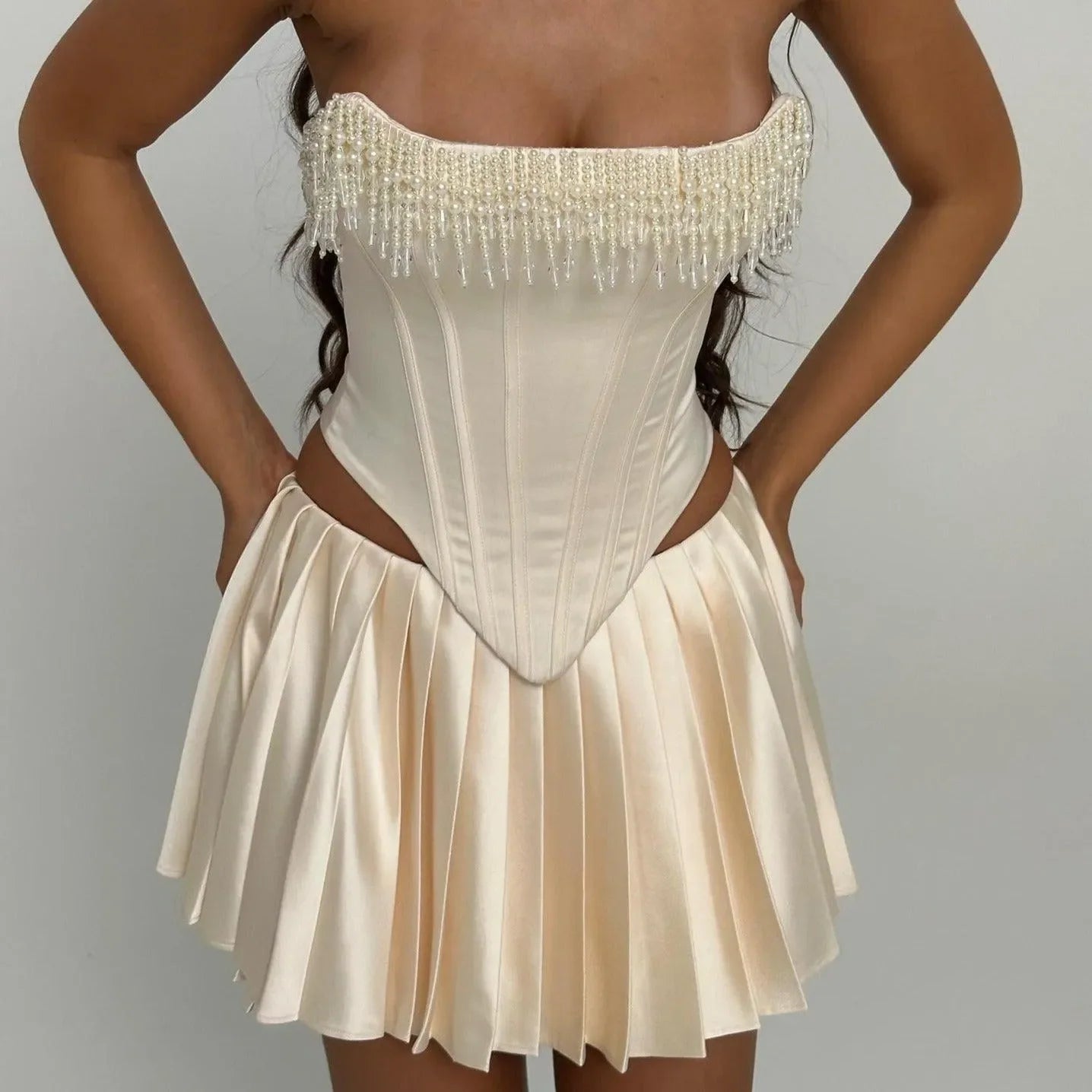strapless corset top with pearl fringe and pleated satin mini skirt, evening look