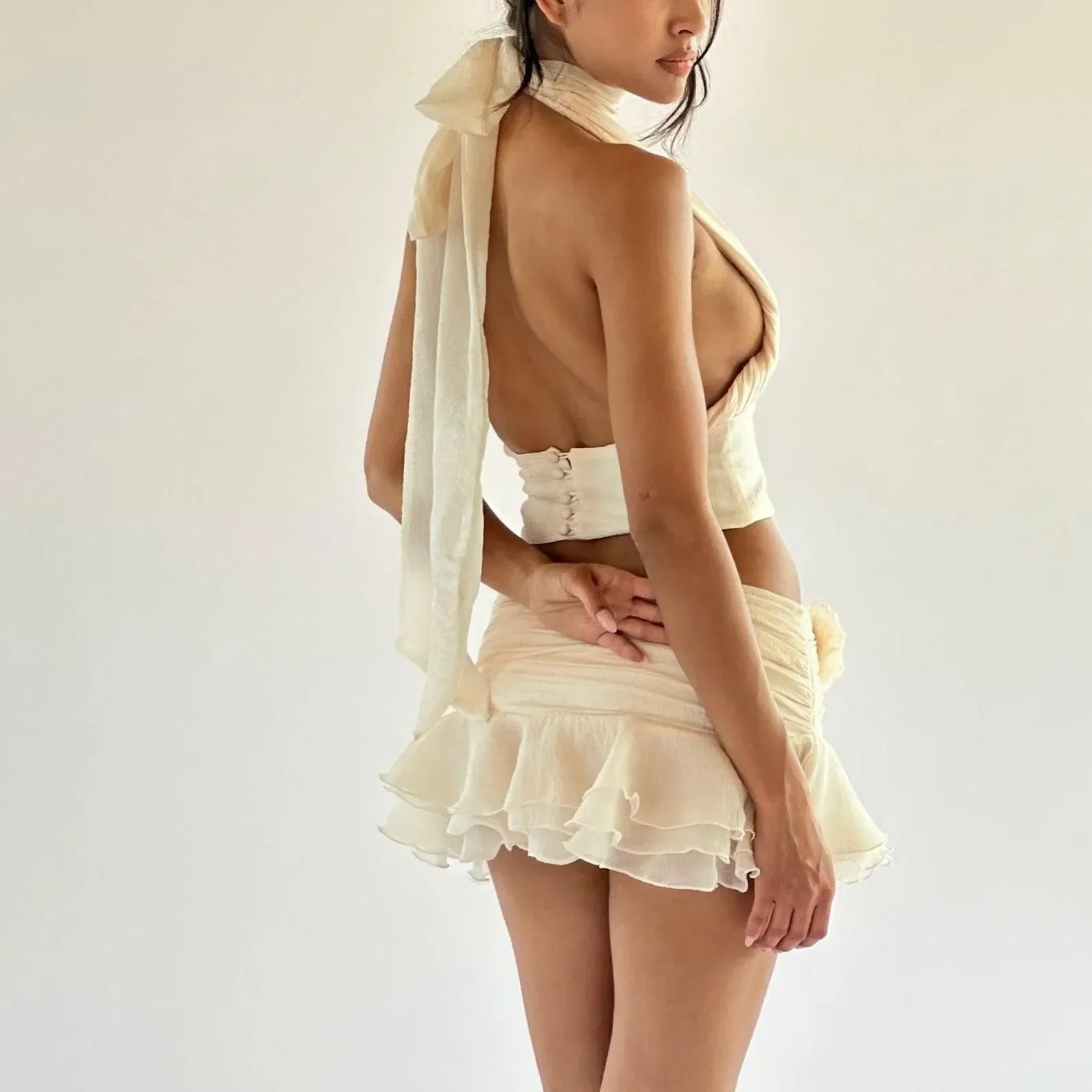 Backless ruffled top and mini skirt set in a light fabric.