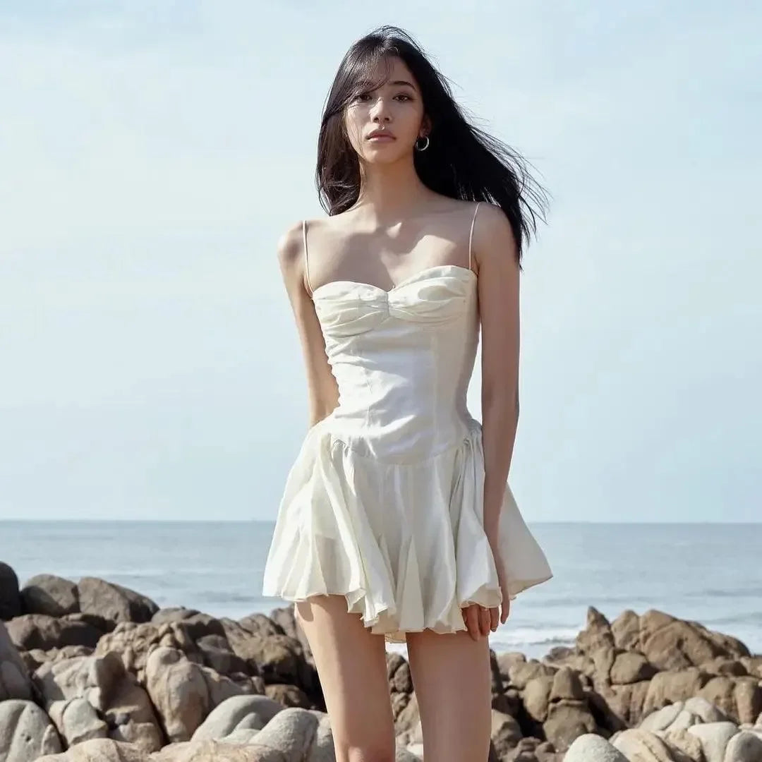 Light cream mini dress with sweetheart neckline and flared skirt, styled with delicate spaghetti straps, perfect for...