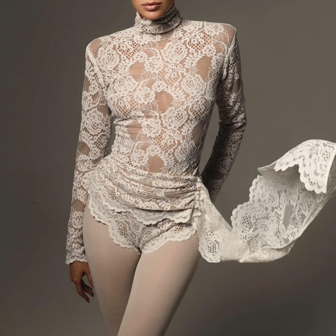 High neck lace romper in soft beige with flouncy lace detailing, styled for a chic, layered evening look.
