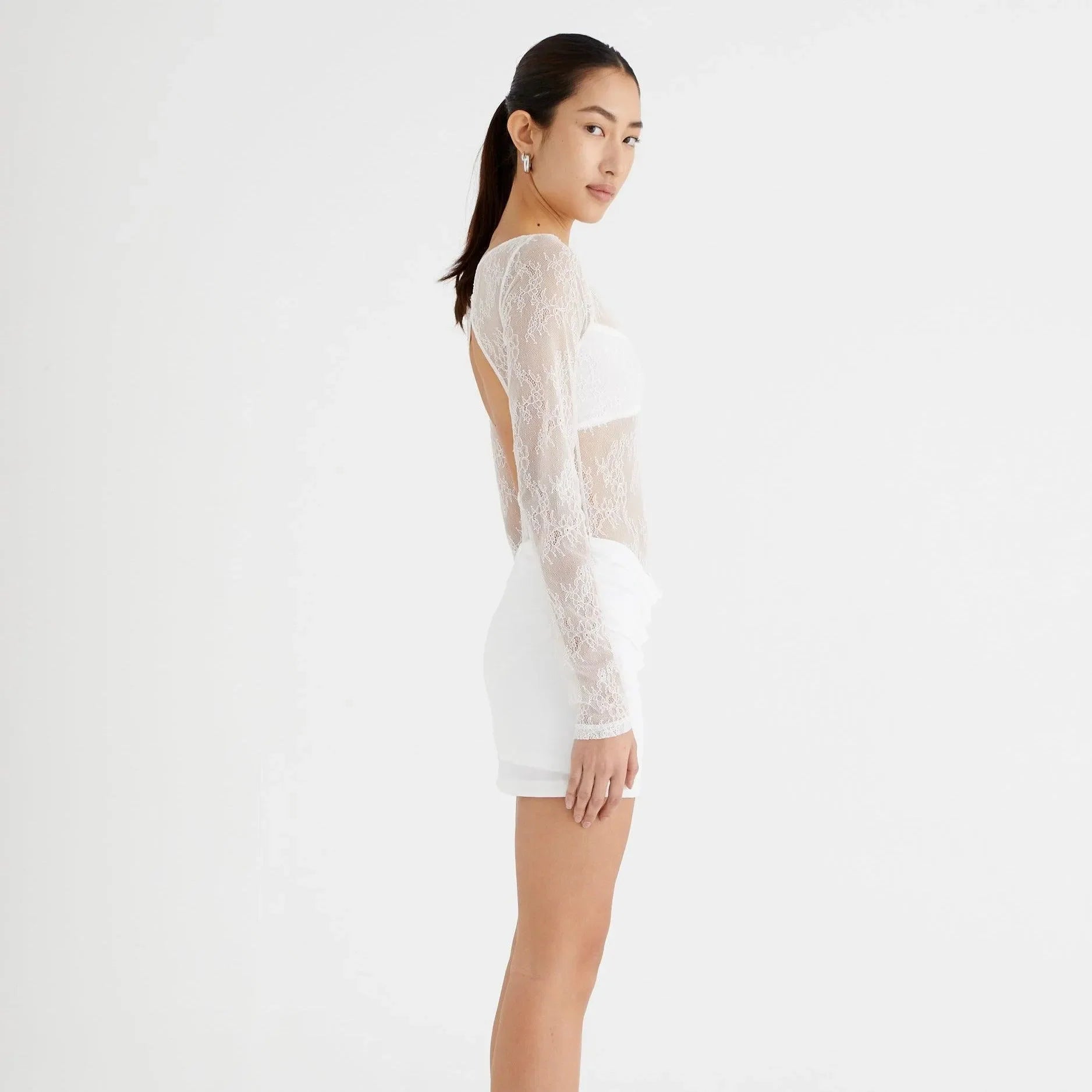 White lace mini dress with long sleeves, featuring a plunging back, perfect for summer outings or beach parties.