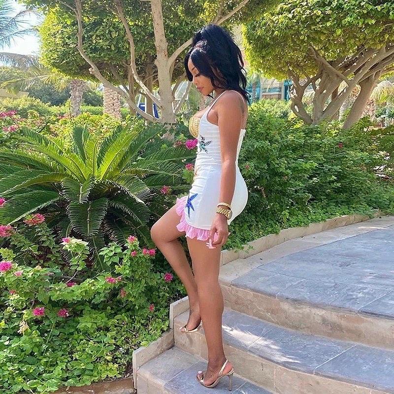 bodycon mini dress with star detail and pink trim, paired with clear strap heels