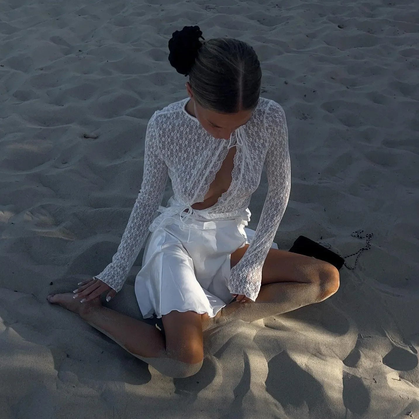 White lace-trim top with front buttons, styled with a flowy white skirt, perfect for a beach outing or casual summer day.