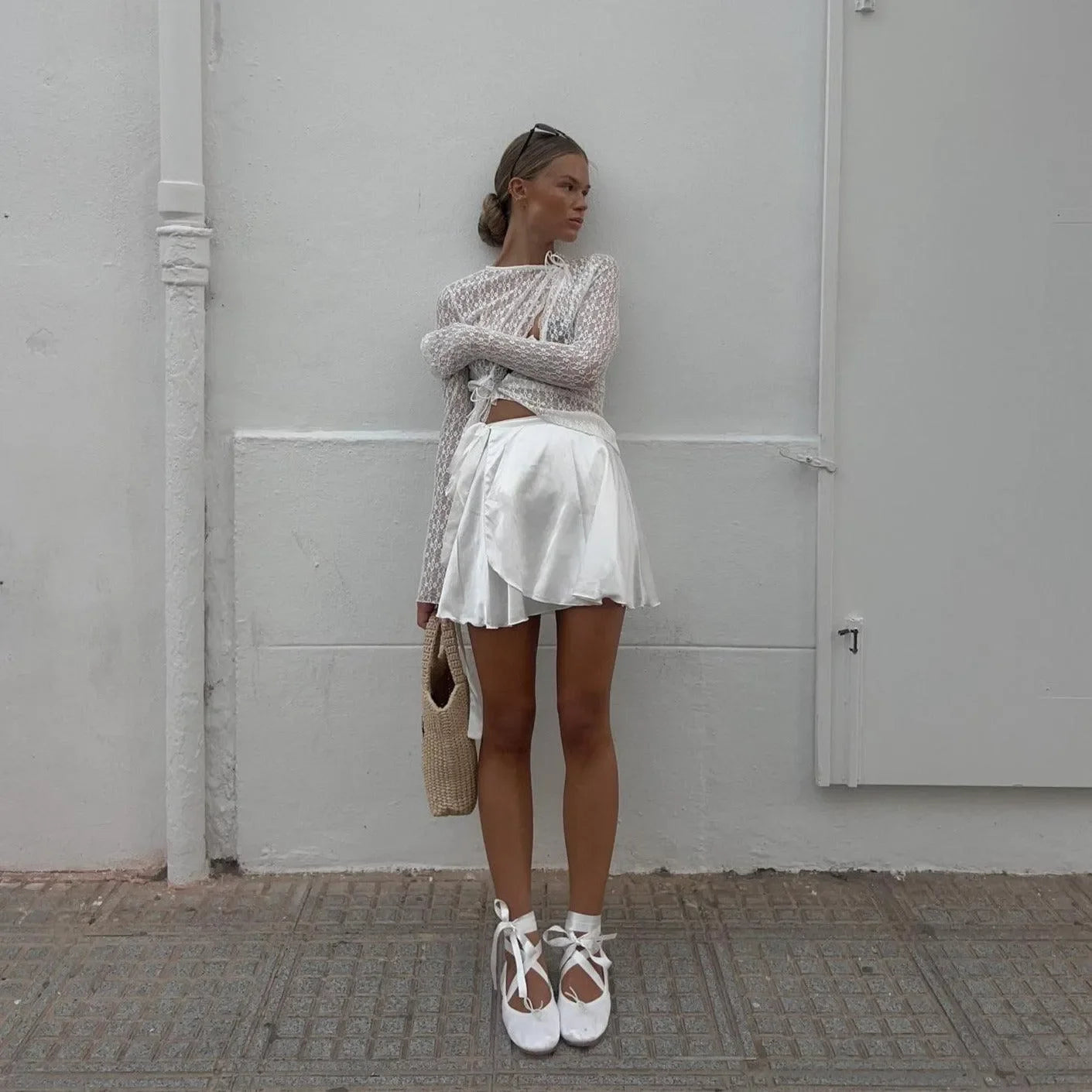 White floral lace trim top, sheer long sleeves, styled with a white skirt and strappy sandals for a chic summer look.