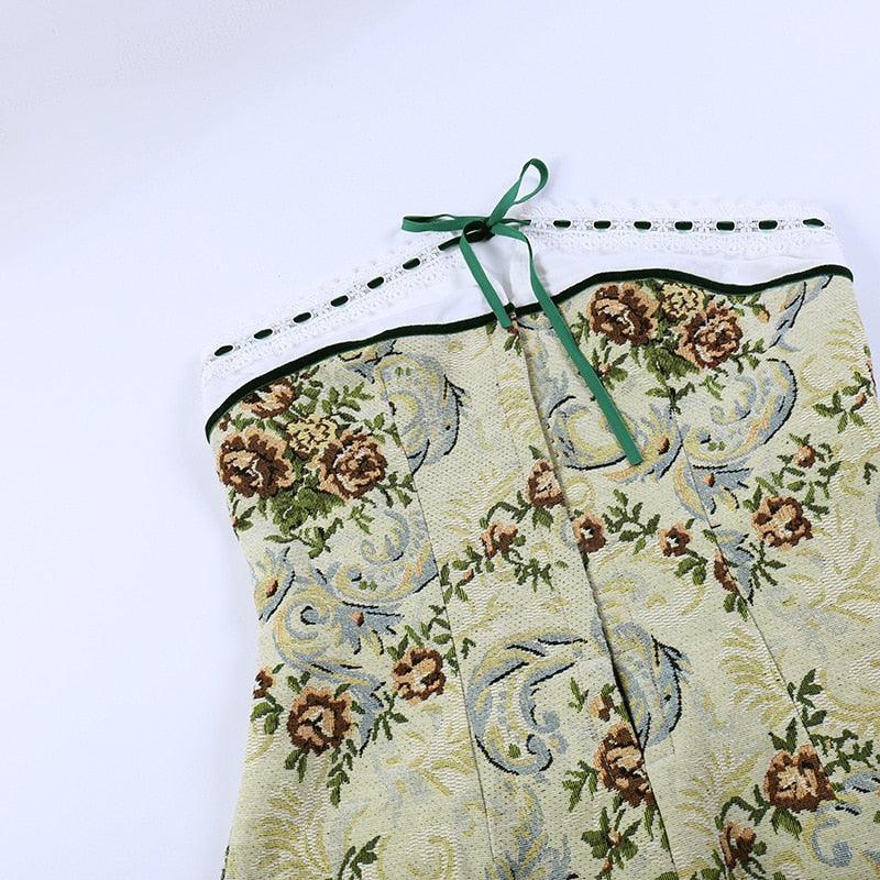 Vintage corset-style mini dress in pale yellow with floral embroidery, features a lace neckline and ties at the back.