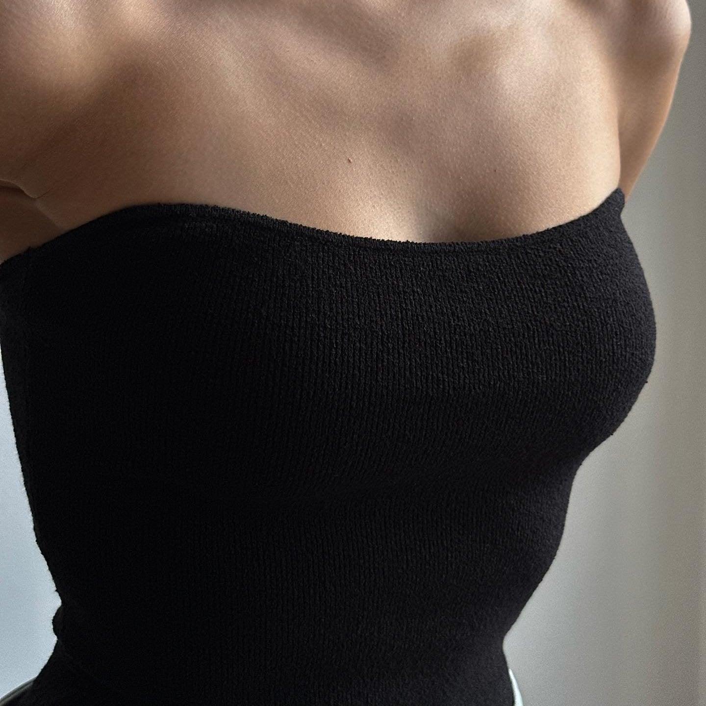 Black knitted tube top featuring a fitted silhouette, perfect for layering or wearing solo in warm weather.
