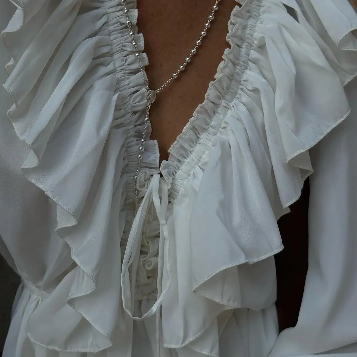 ruffled white blouse with deep neckline, elegant look