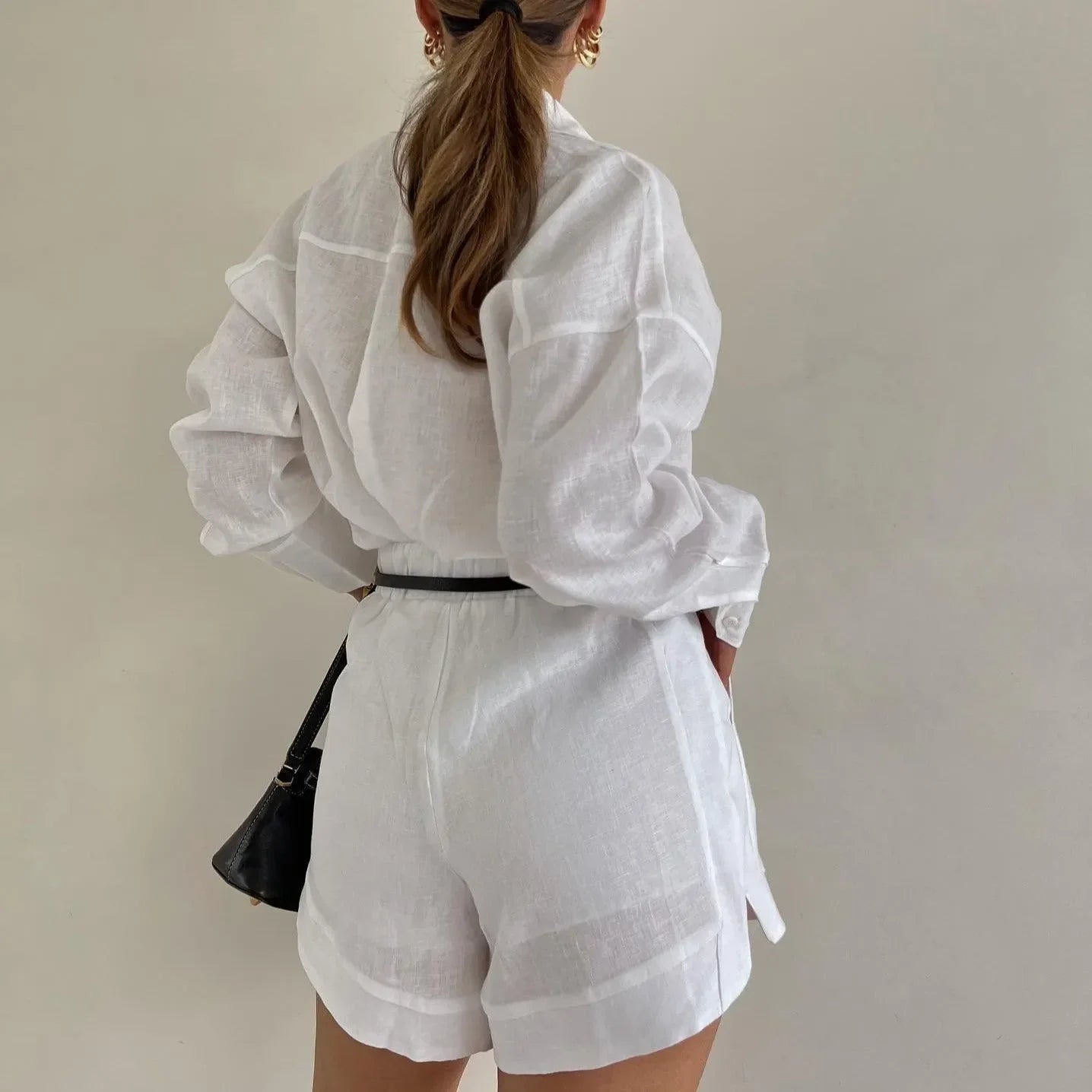 White linen two-piece set featuring a button-up shirt and high-waisted shorts, perfect for summer outings.