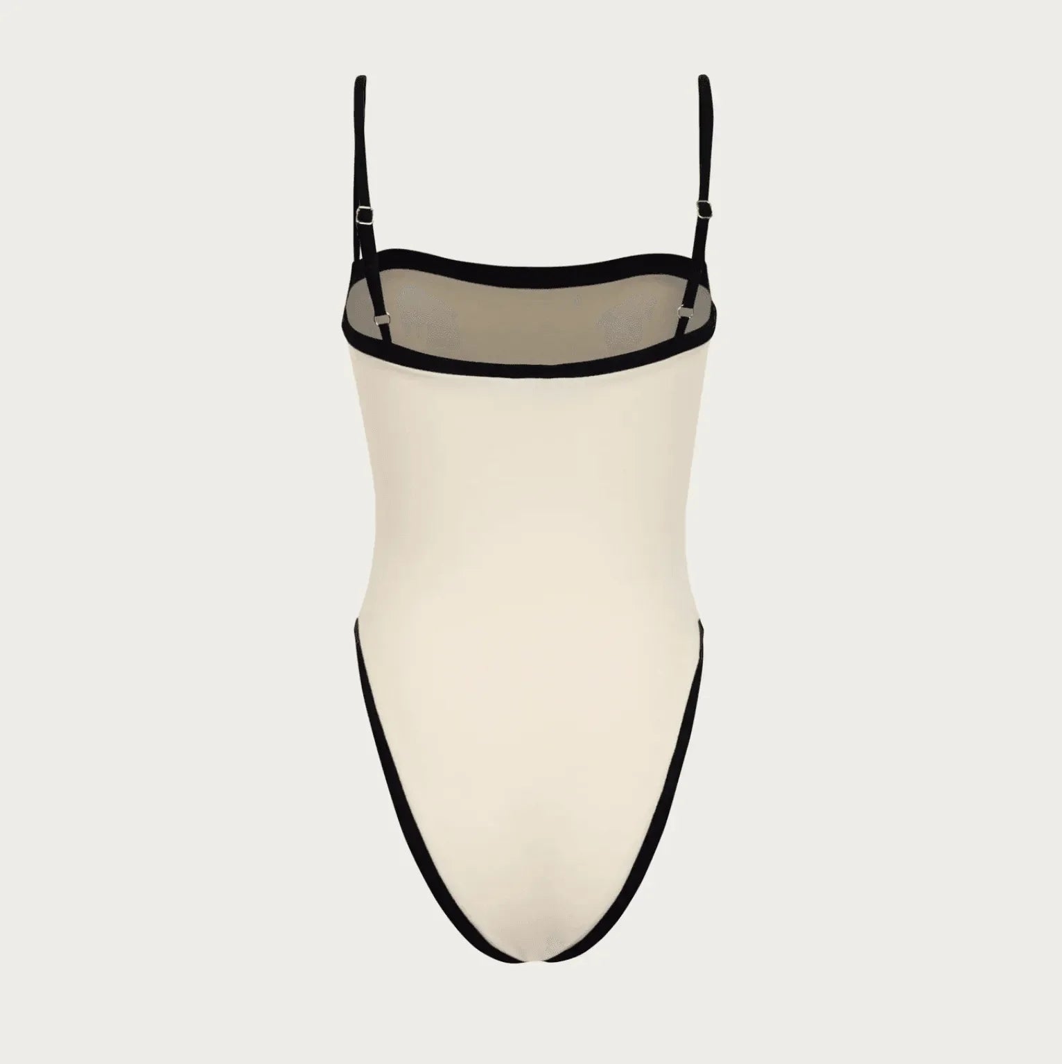 Ivory one-piece swimsuit with black trim, adjustable straps, and a sleek, minimalist design, perfect for sunbathing.