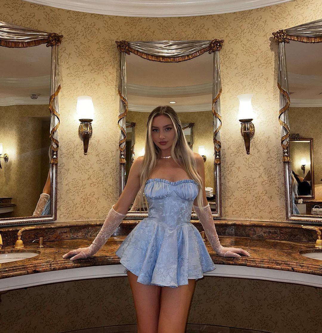 Light blue satin corset mini dress with a fitted bodice and flared skirt, styled with sheer gloves for a chic look.