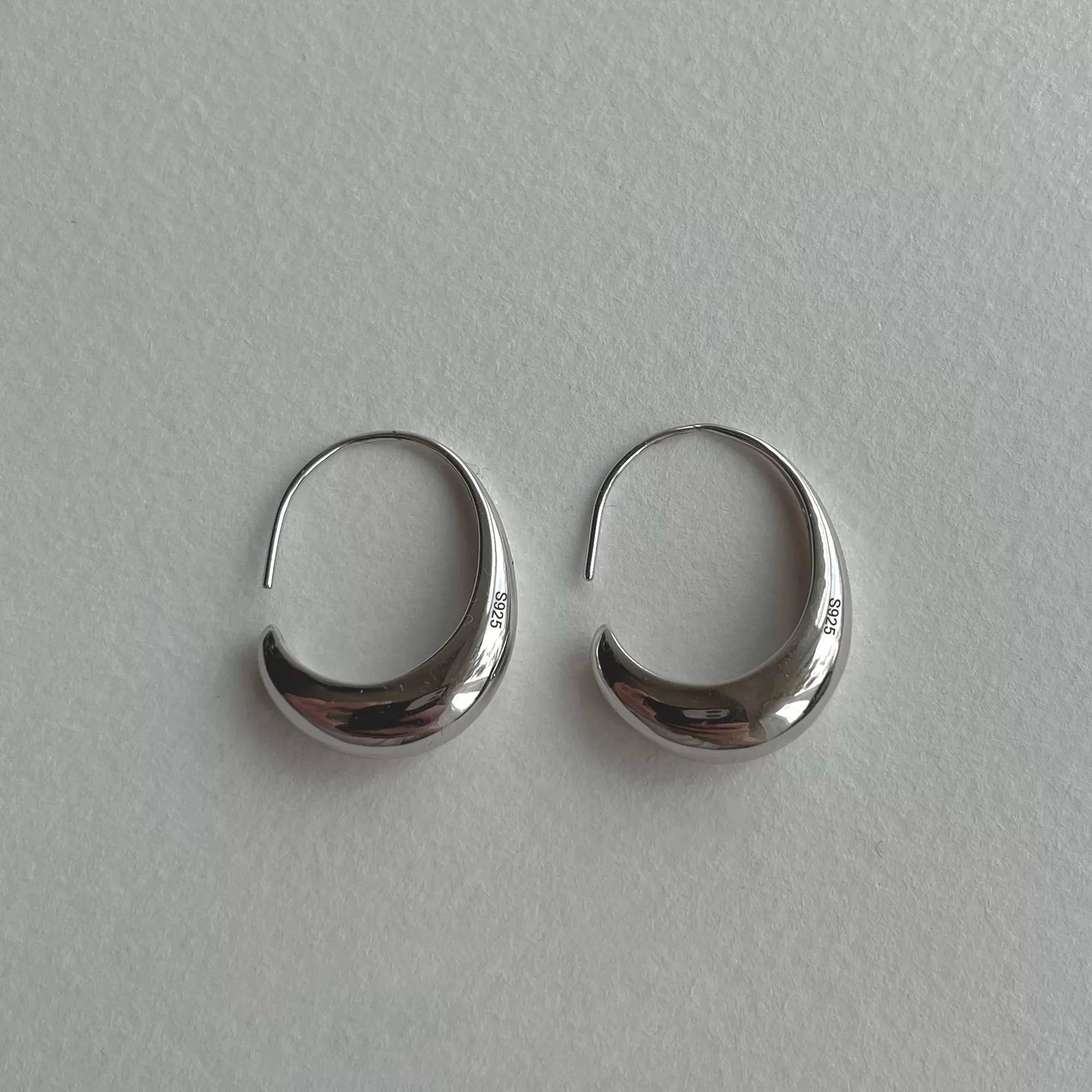 crescent-shaped silver hoop earrings