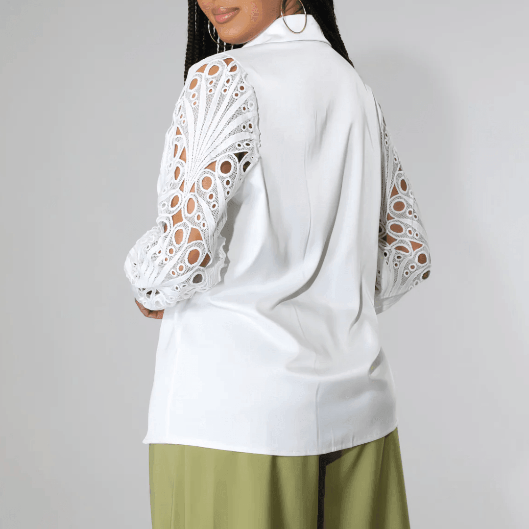 White blouse featuring elegant lace detailed sleeves, styled with relaxed fit, perfect for chic layering or standalone wear.