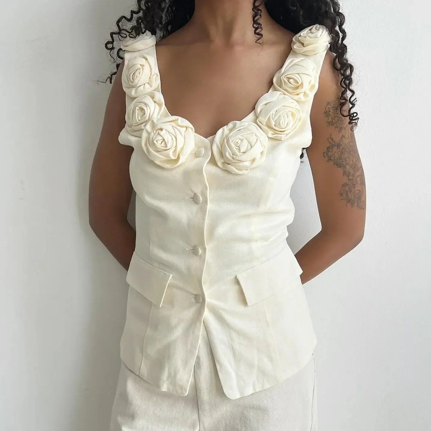 cream sleeveless top with floral embellishments