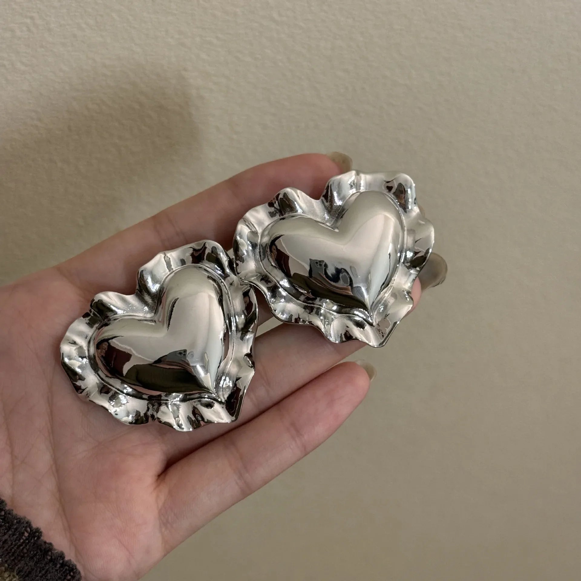 silver heart-shaped earrings with ruffled edges