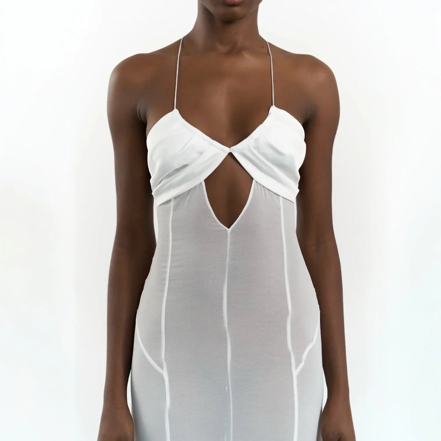 White maxi dress featuring mesh cutouts and lace-up detailing, styled with a deep V-neck and adjustable straps.
