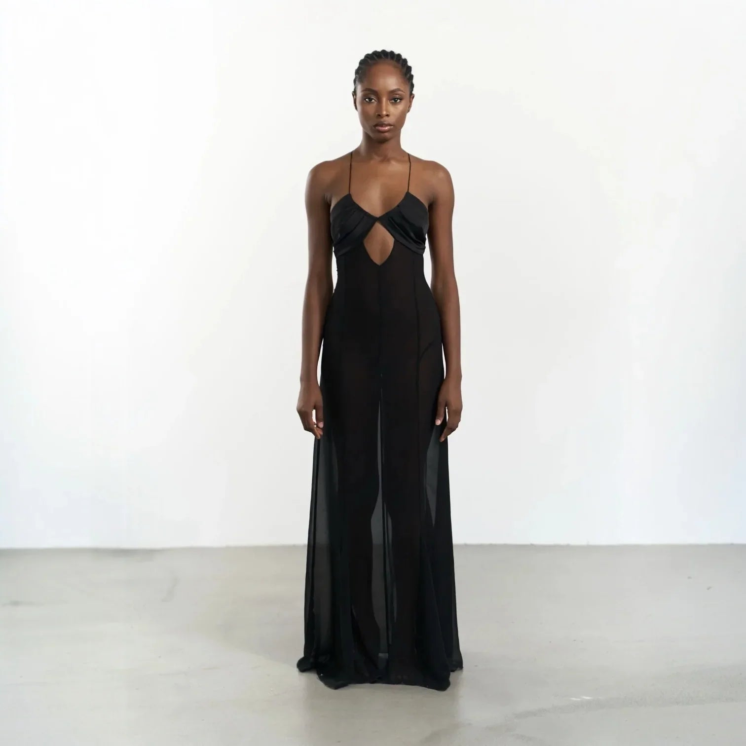 Black maxi dress with mesh cutouts and lace-up back, elegantly styled with a fitted silhouette for a sleek look.