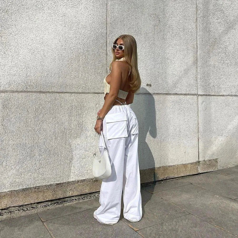 backless crop top with wide-leg cargo pants and white handbag
