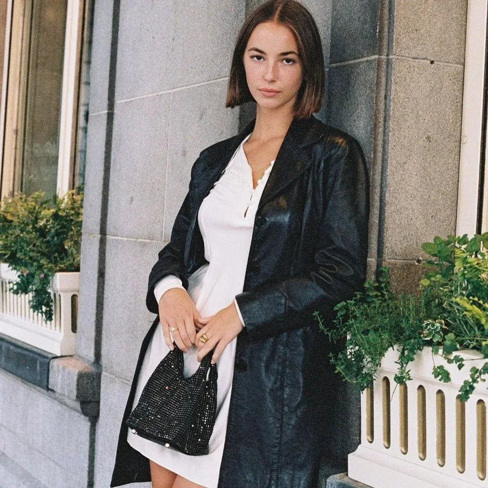 white mini dress with black leather coat and rhinestone handbag, chic evening look