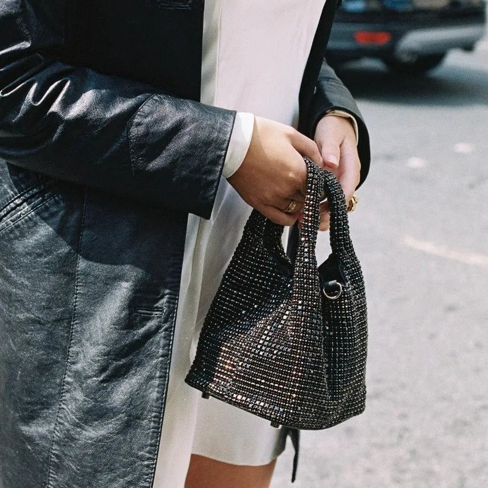 Leather trench coat with a small rhinestone studded handbag.