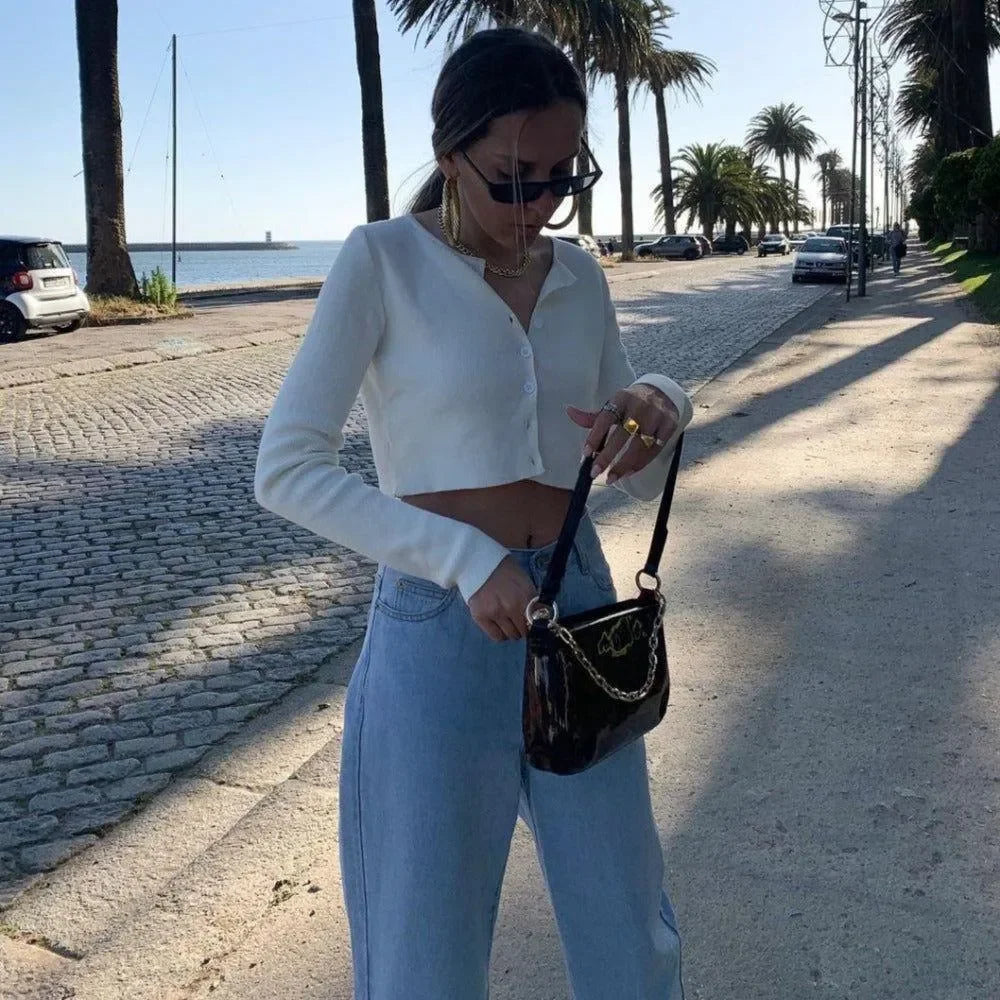 Cropped button-up cardigan with high-waisted jeans and chain-strap bag, casual day look