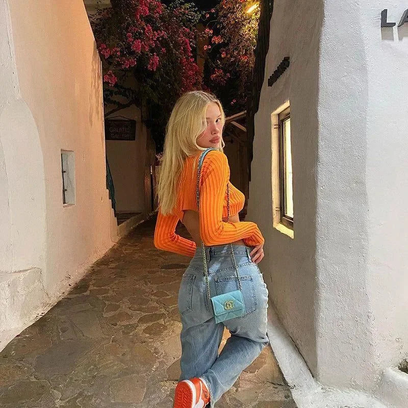 ribbed orange backless top with light-wash jeans and blue shoulder bag, casual outing style
