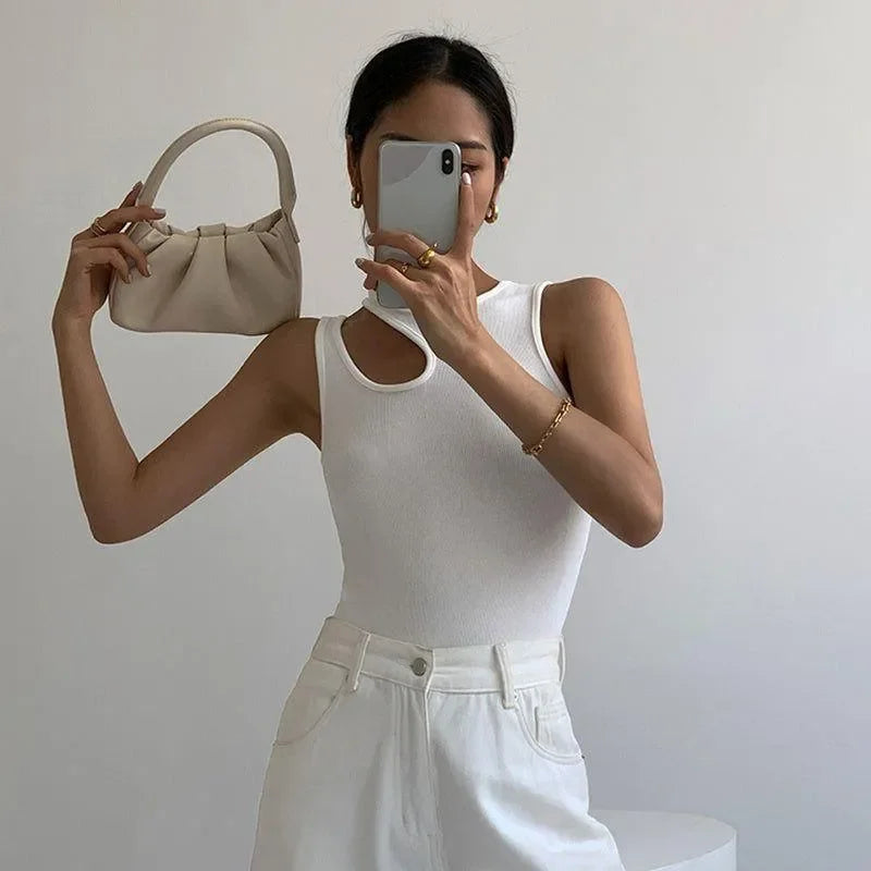 white ribbed tank top and high-waisted white pants paired with beige handbag, casual chic look