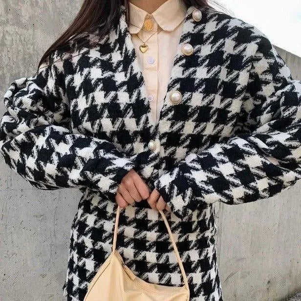 houndstooth coat with oversized buttons, paired with a beige handbag