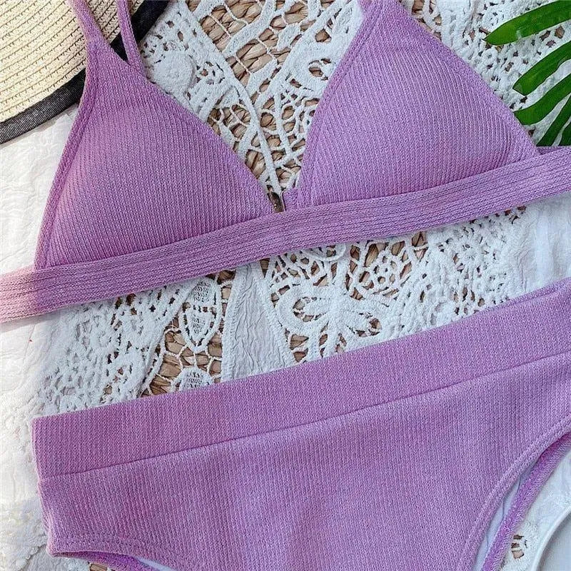 Purple ribbed knit bikini set on lace background.