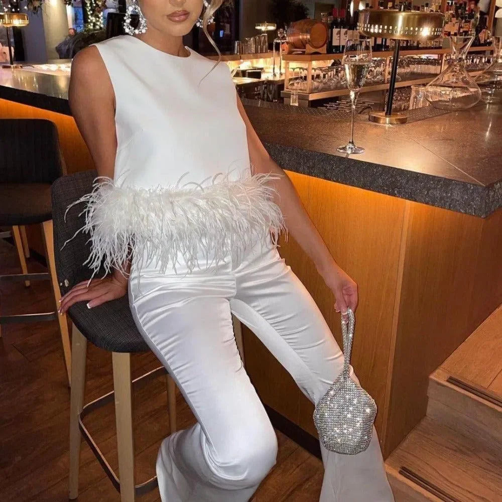 White feather-trim top and satin pants with a sparkling silver bag for an evening look.