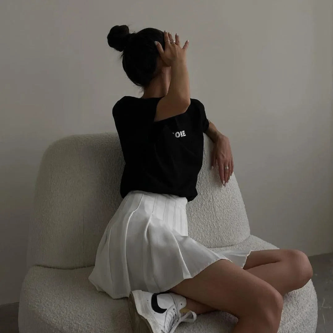 pleated white mini skirt with casual black top, daywear style