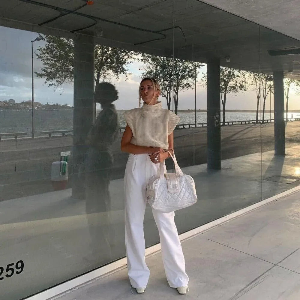 knit sleeveless top with wide-leg trousers and quilted handbag, casual daywear