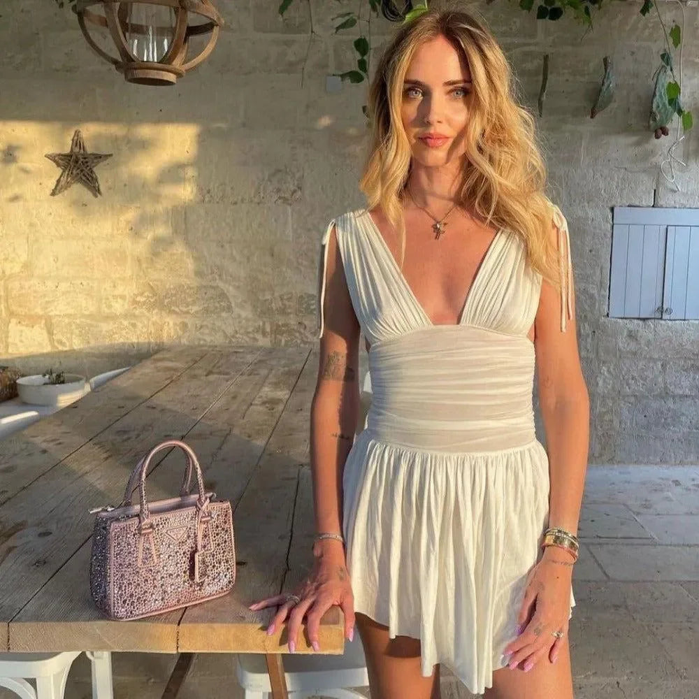 White ruched mini dress with sleeveless design.