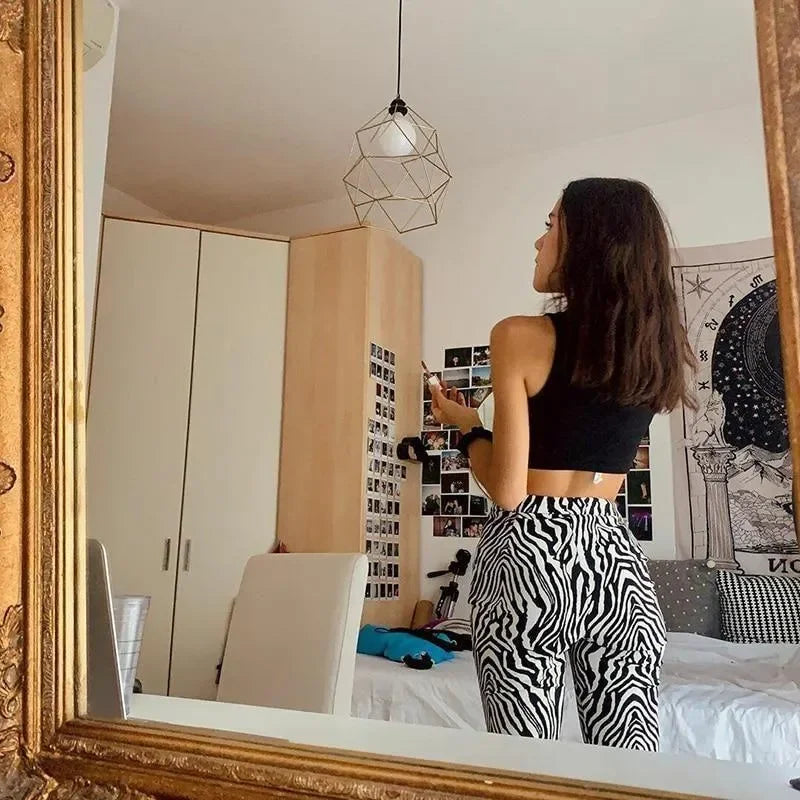 Black crop top with zebra print high-waisted pants, casual look.