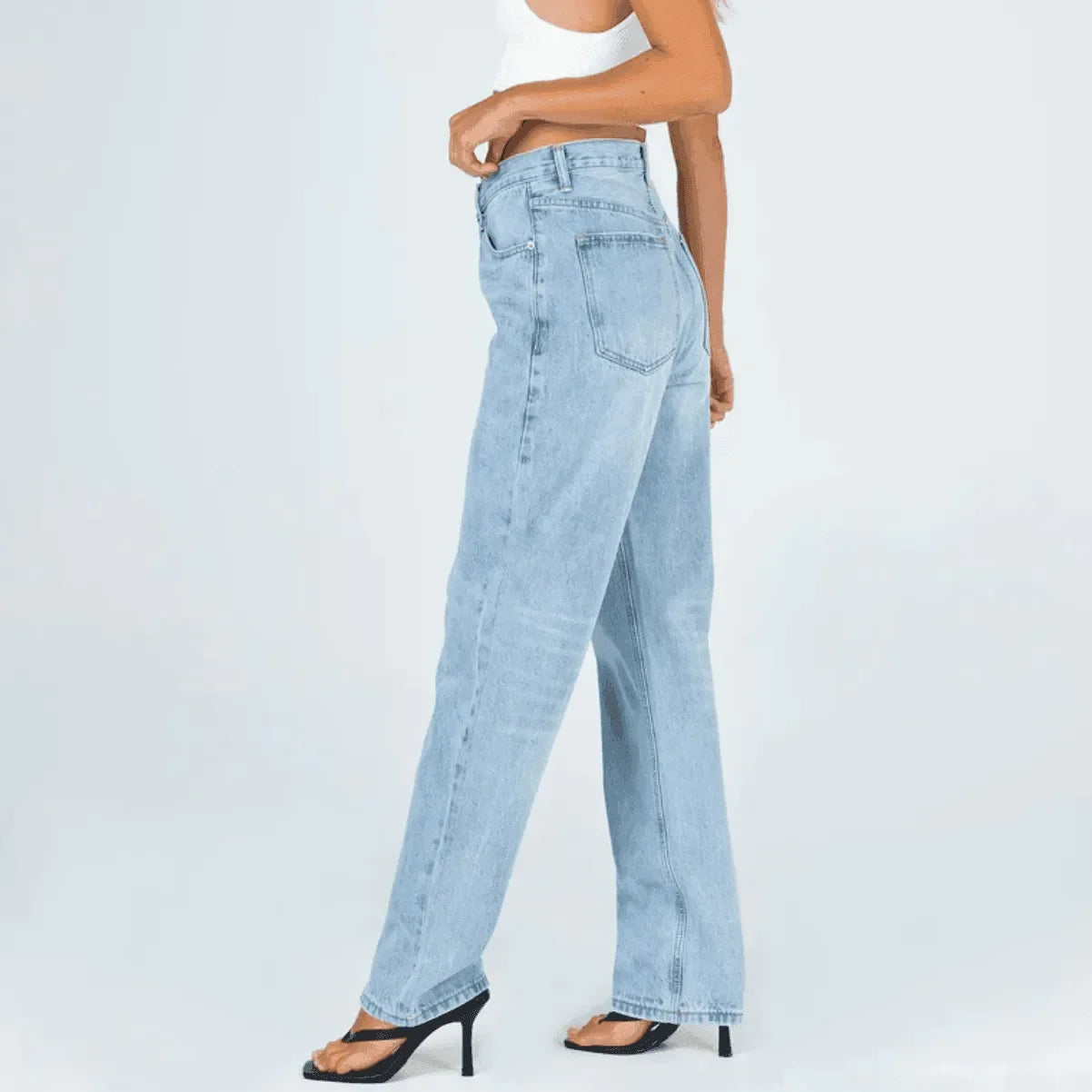 High-waisted light wash denim jeans paired with black heels.