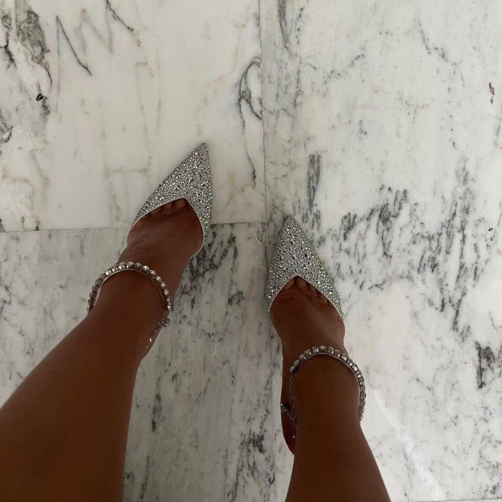 Silver glittery high heels on a marble floor