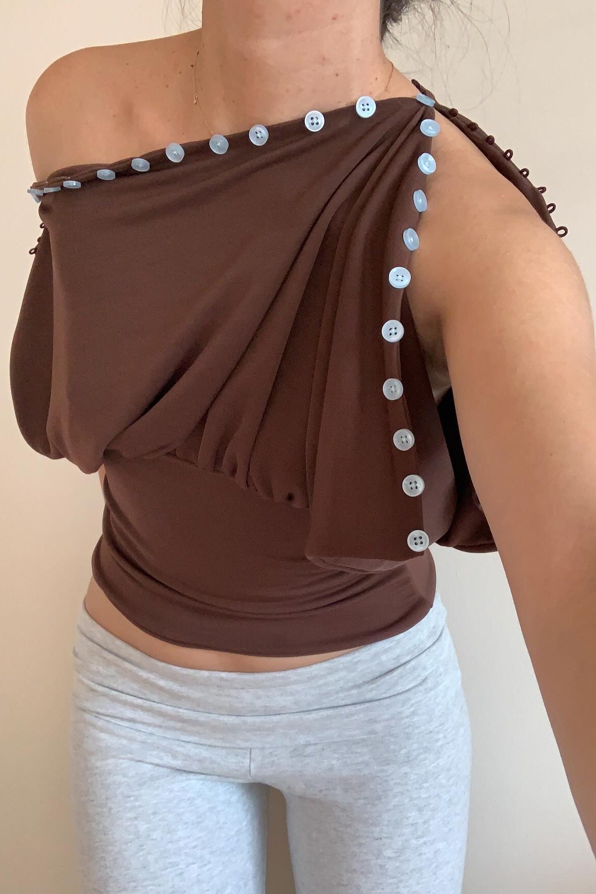 Brown convertible button top styled one-shoulder, draped silhouette detail
