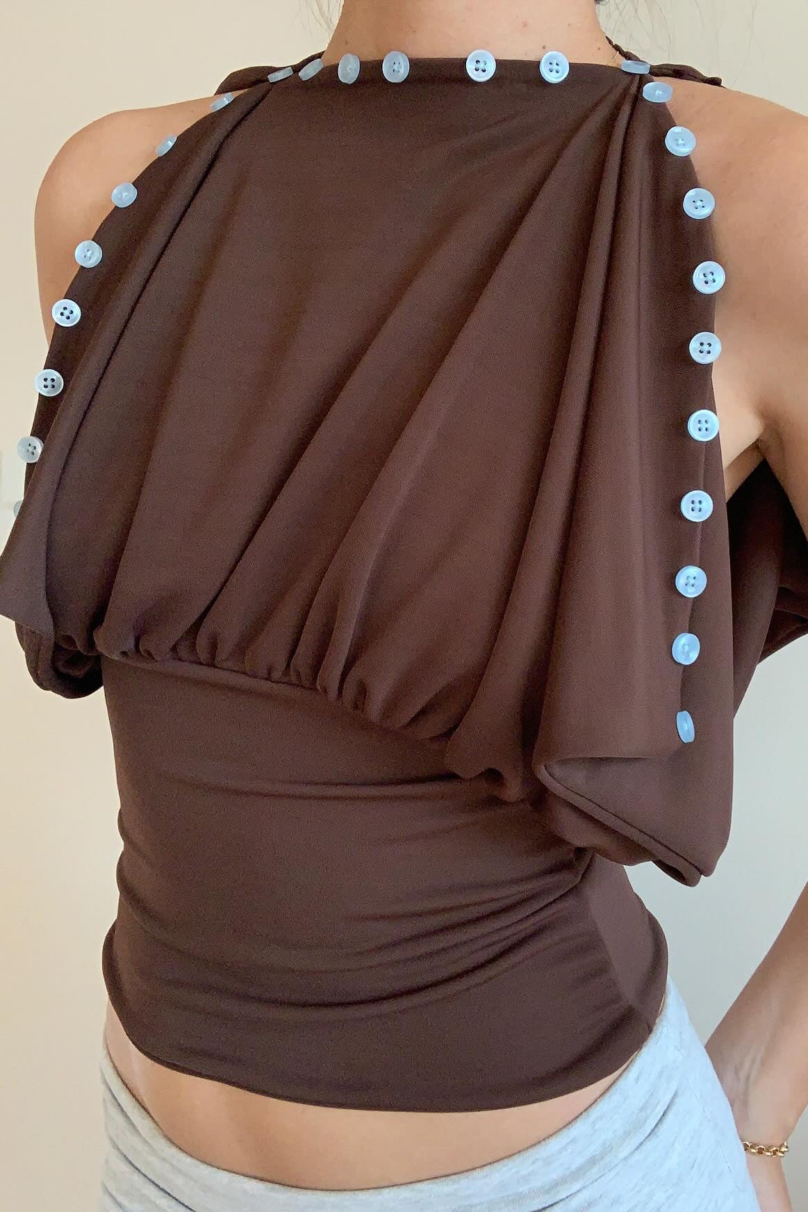 Chocolate brown convertible draped top with decorative button trim, back view off-shoulder style