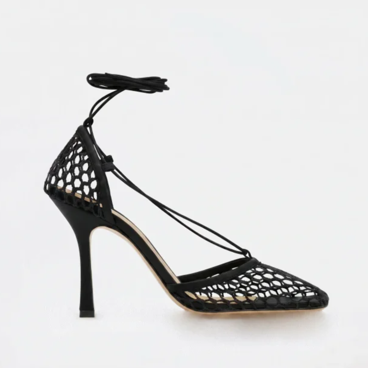 Black high-heeled shoe with mesh design on a white background