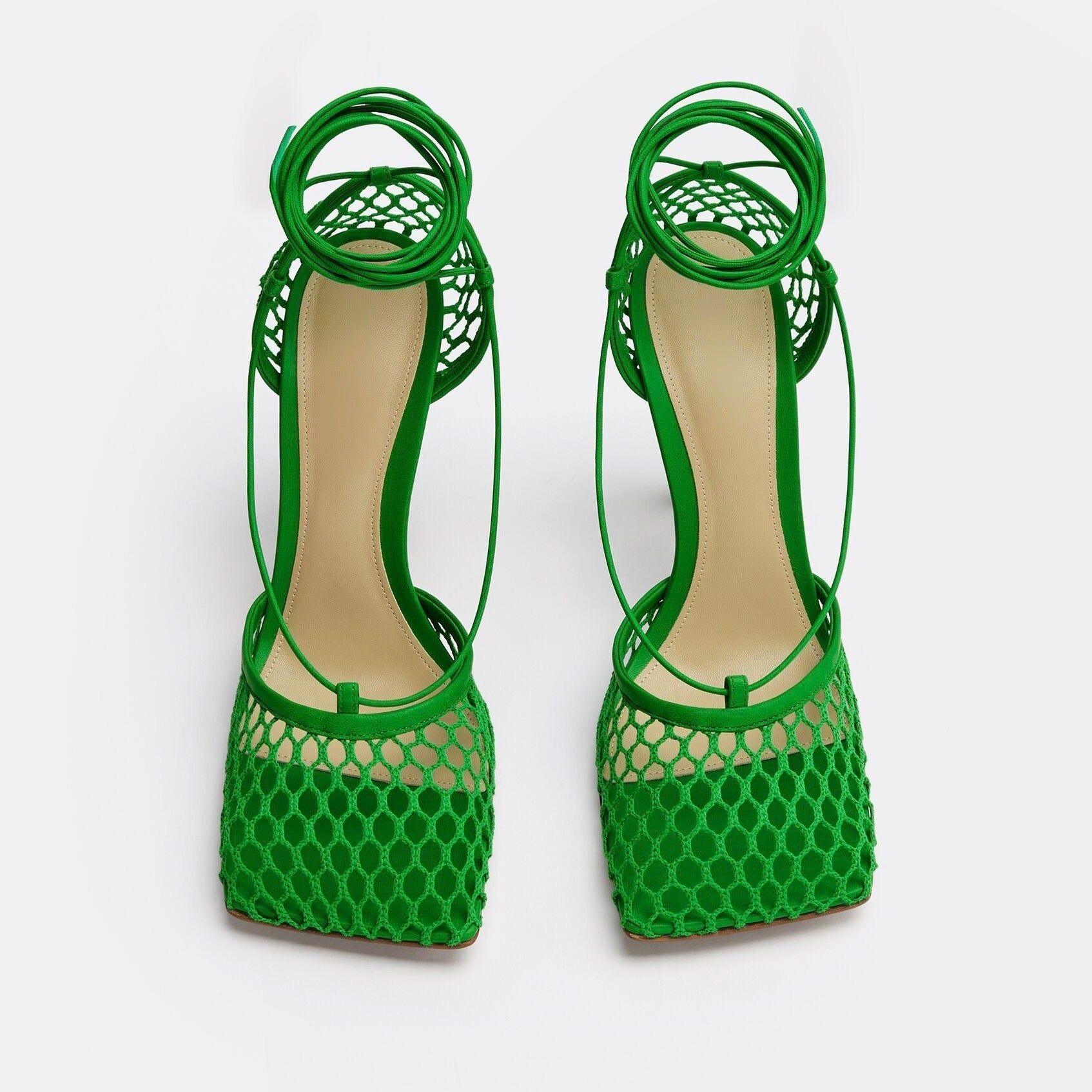 Green high-heeled shoes with open-toe design on a white background