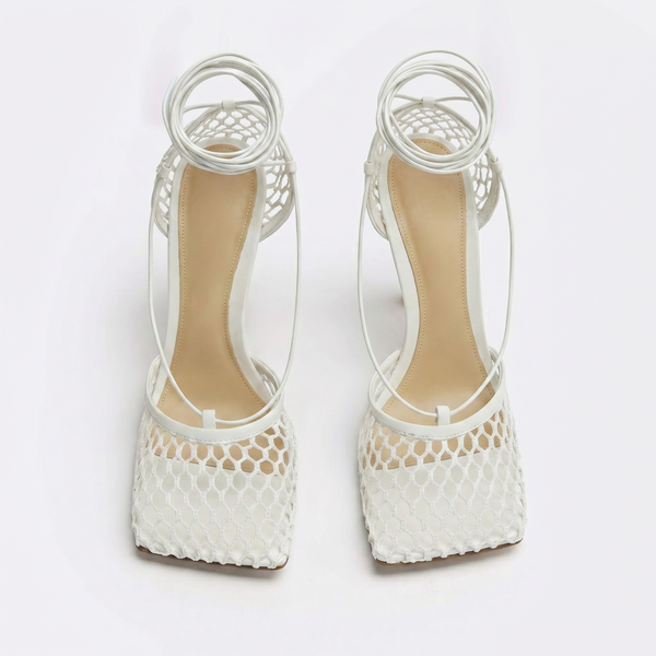 White high-heeled shoes with mesh design on a white background