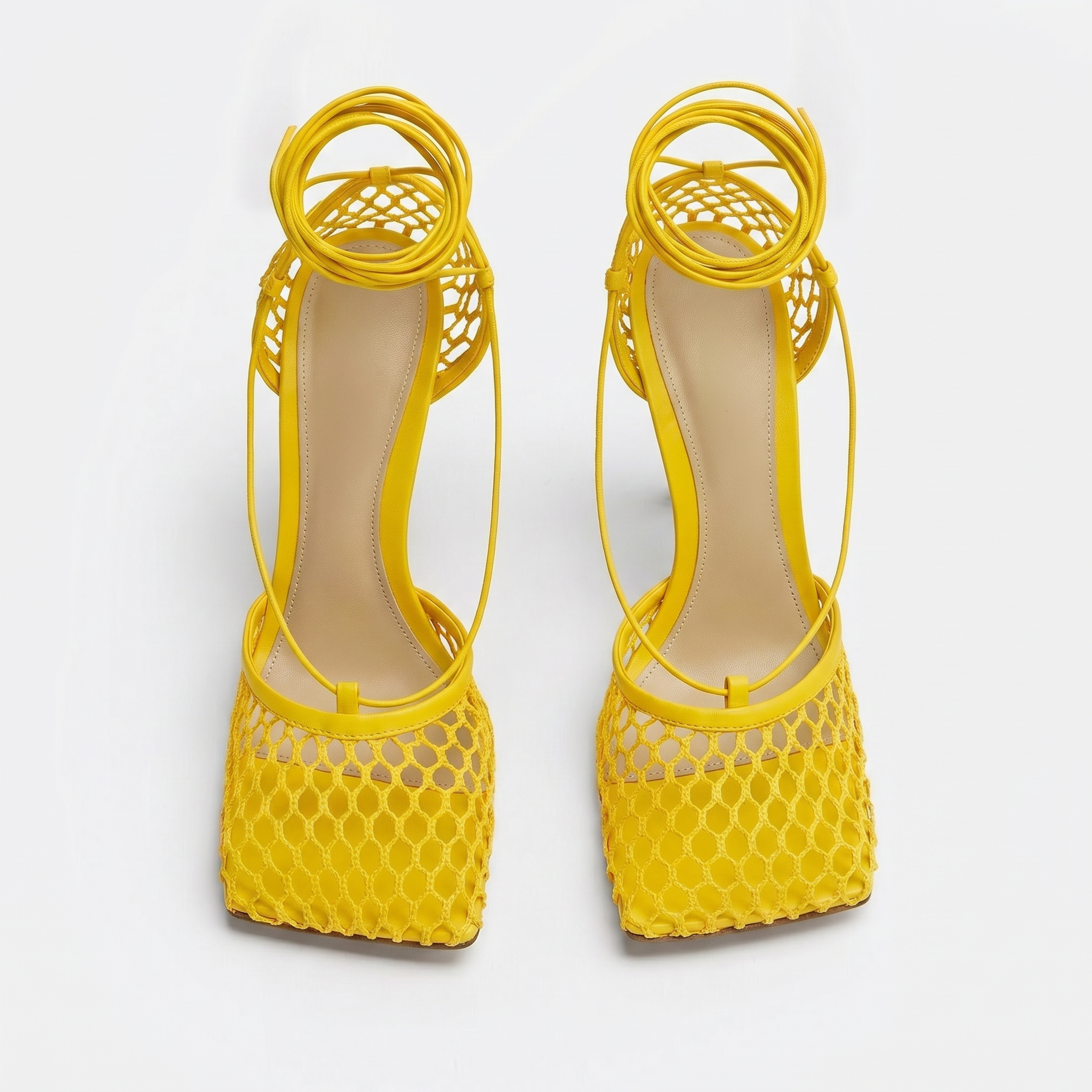 Yellow high-heeled shoes with open-toe design on a white background