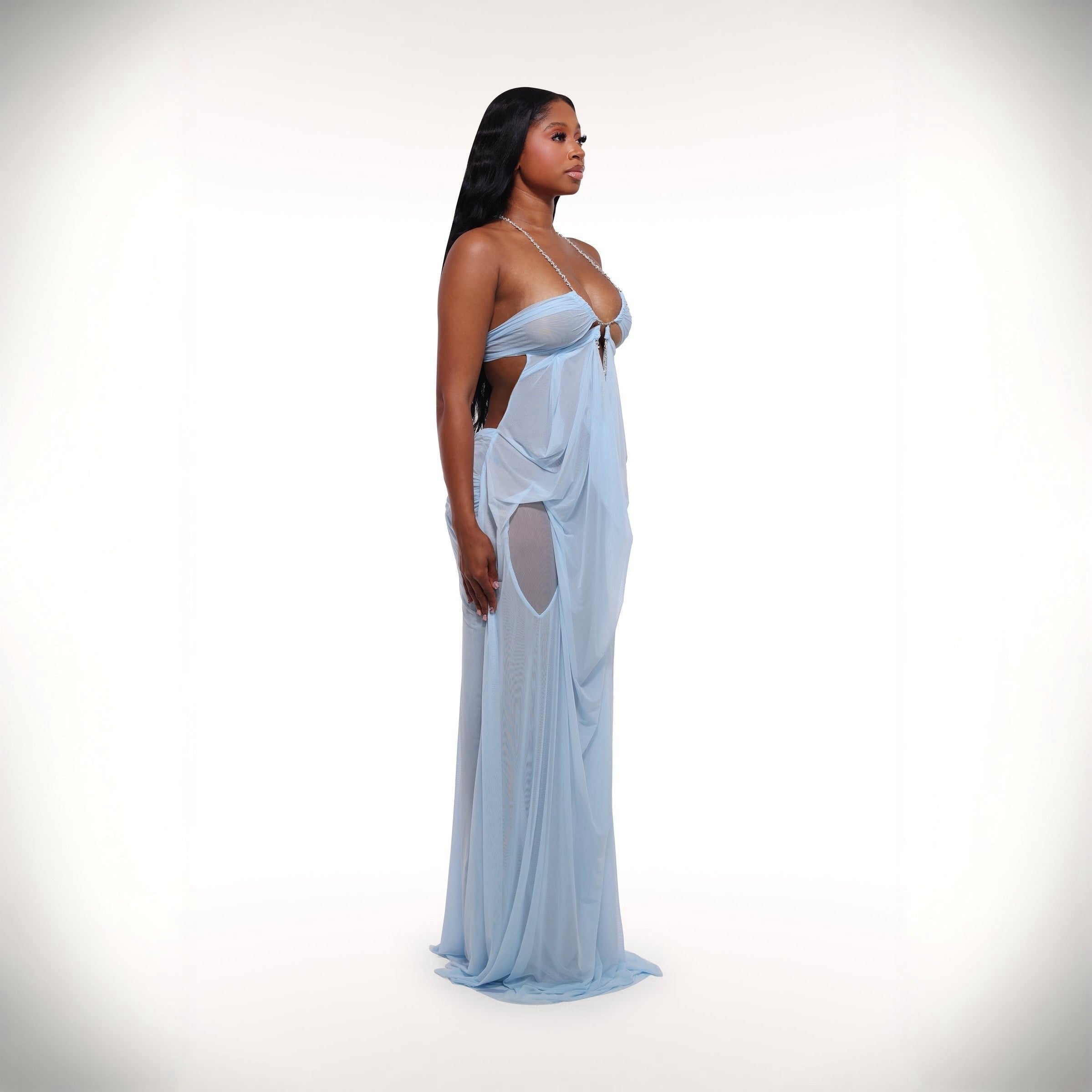 Woman wearing a light blue evening gown with cut-out design on a white background